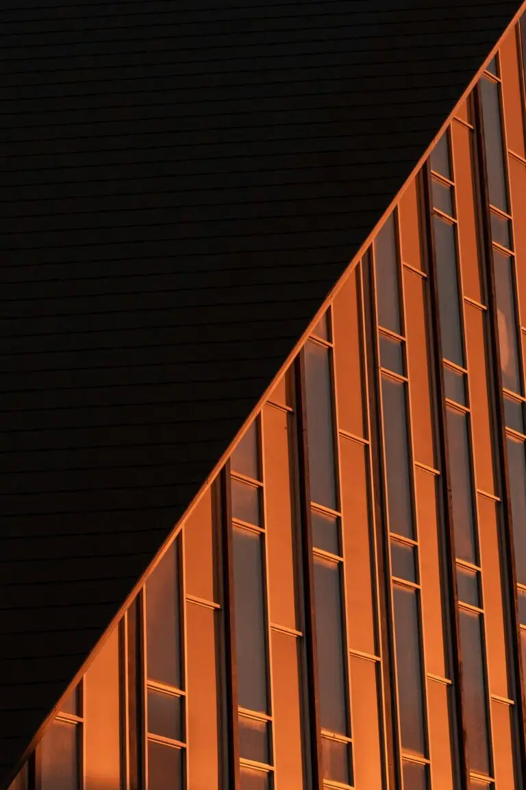 Moderne Glasfassade mit hochwertiger Fassadenverkleidung im Abendlicht
